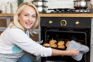 tiro-medio-mujer-sonriente-croissants-hornear_23-2148334777